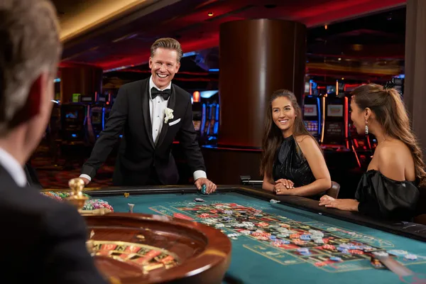 Um close de moedas douradas caindo ao redor de uma roleta girando, representando a ação imersiva do cassino no 63V.